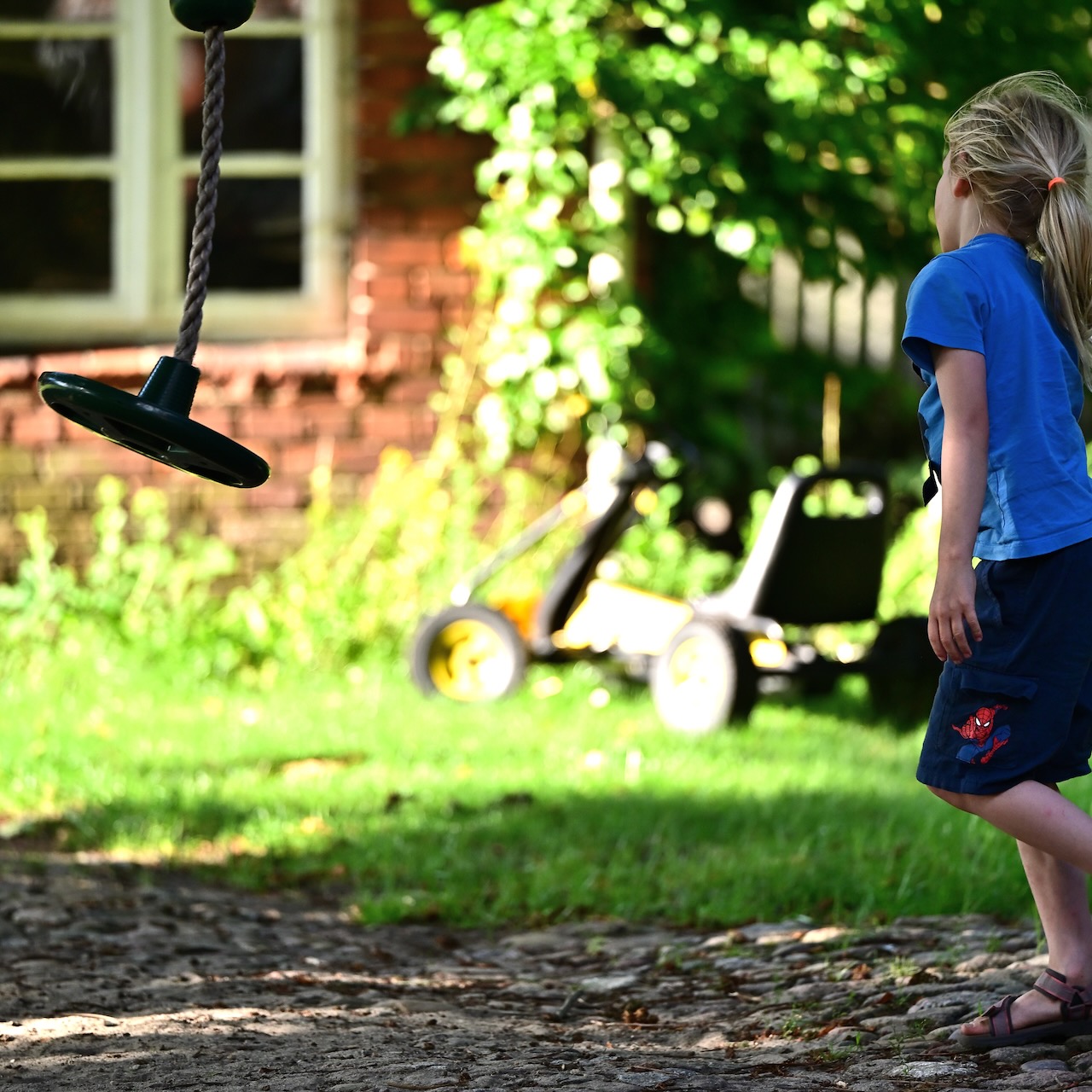 A boy walking up to a swinging rope