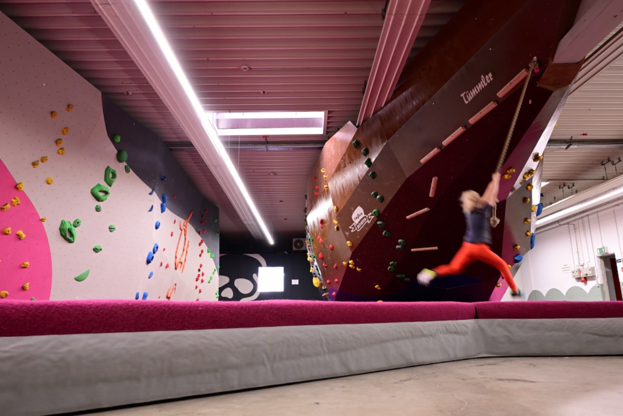 Image of a kid using a swinging rope in a boulder gym