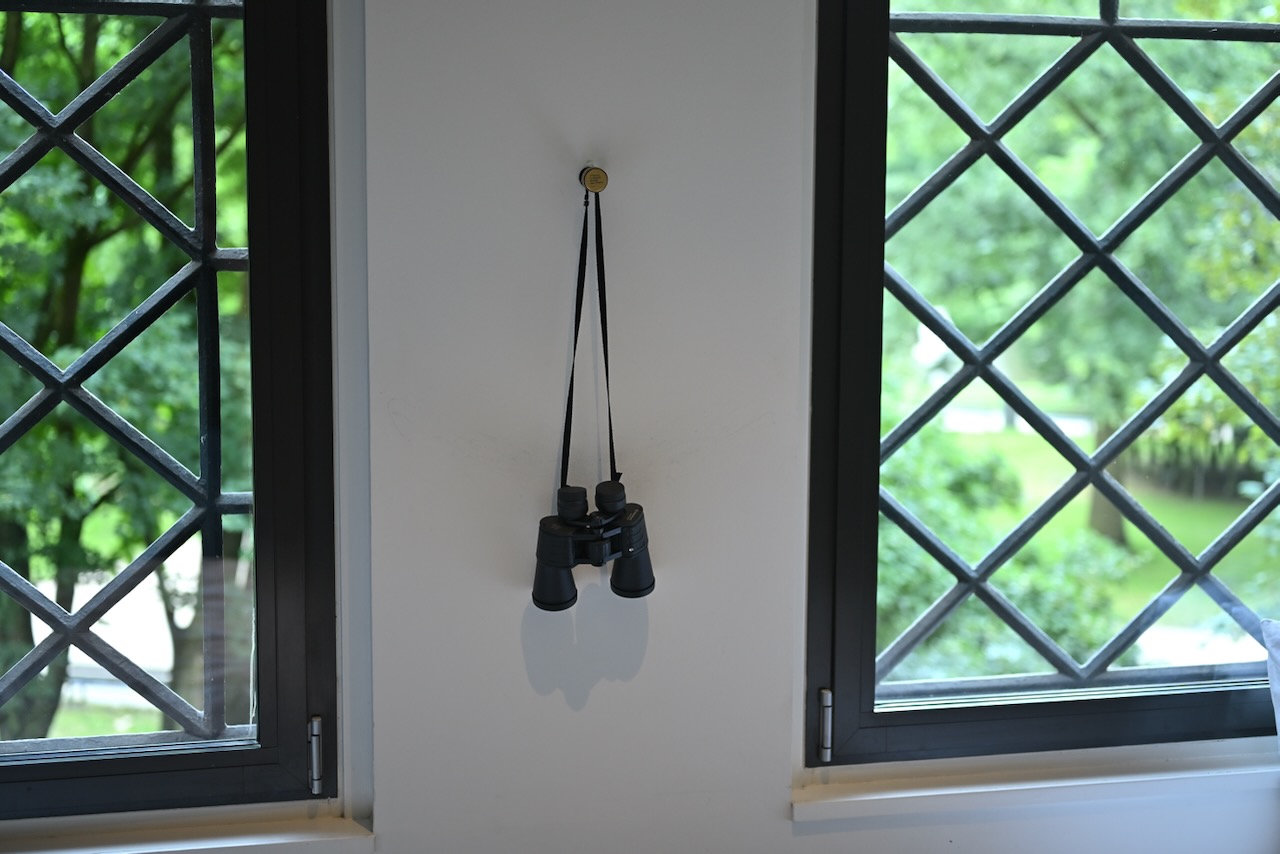A binocular hanging in front of two windows.